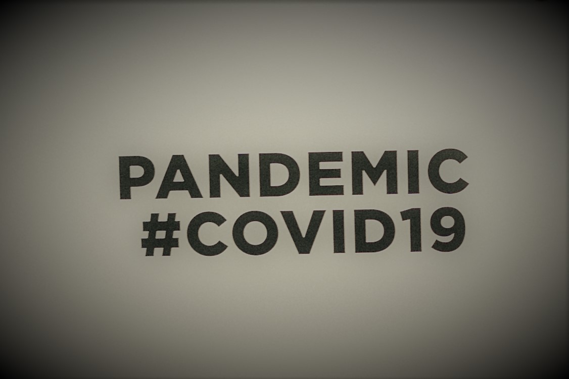 Canva-People-Holding-A-Placard-With-Pandemic-Covid19-Text.jpg